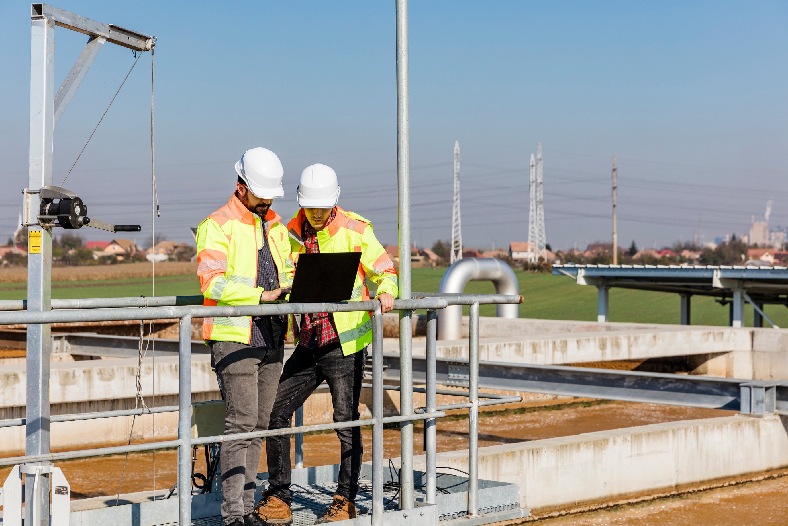 Engineers working on water treatment plant with laptop